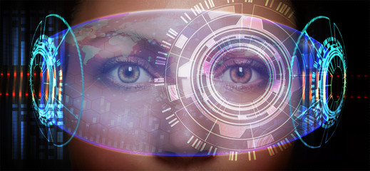 Close-up portrait of young and beautiful woman with the virtual futuristic glasses ( technology concept).Virtual holographic interface and young woman wearing glasses