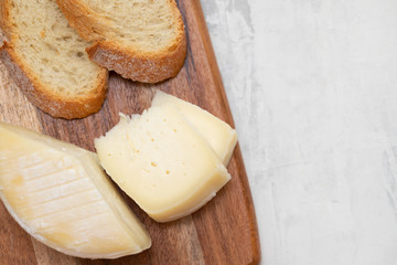 cheese with bread on wooden board