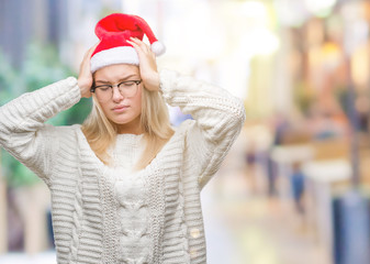 Young caucasian woman wearing christmas hat over isolated background suffering from headache desperate and stressed because pain and migraine. Hands on head.