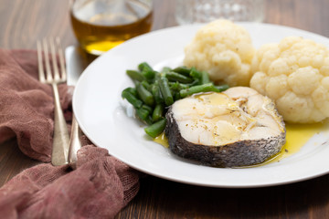 boiled fish with boiled vegetables on white plate
