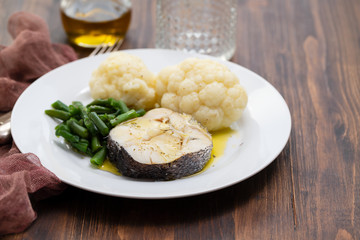 boiled fish with boiled vegetables on white plate