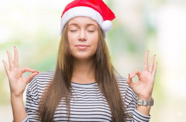 Young beautiful caucasian woman wearing christmas hat over isolated background relax and smiling with eyes closed doing meditation gesture with fingers. Yoga concept.