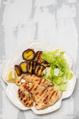 grilled chicken with vegetables on white dish