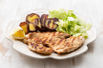 grilled chicken with vegetables on white dish