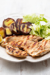 grilled chicken with vegetables on white dish