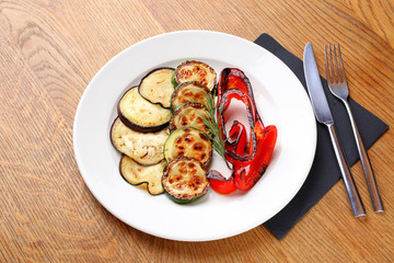 Stock Photo -  Roasted bell peppers and eggplant on a white plate.
