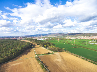 Luftaufnahme einer Landschaft im Sommer mit Feldern, Wald und Stromleitungen in Deutschland,...