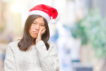 Young asian woman wearing christmas hat over isolated background thinking looking tired and bored with depression problems with crossed arms.
