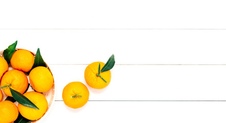Pile of mandarins in white bowl on white wooden background
