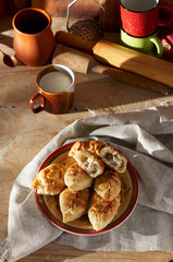 Russian meat piroshki. Traditional hand mini pies on wooden background