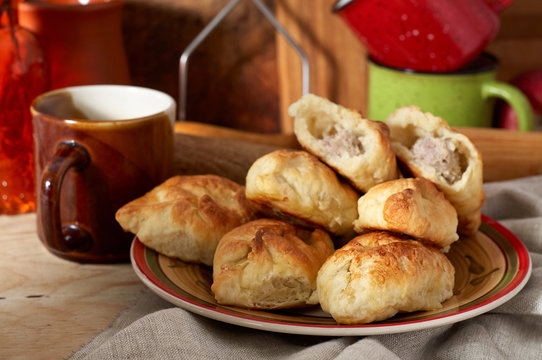 Russian meat piroshki. Traditional hand mini pies on wooden background