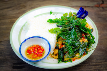 fried rice with basil on old wood background.