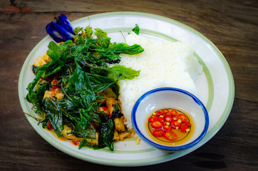 fried rice with basil on old wood background.