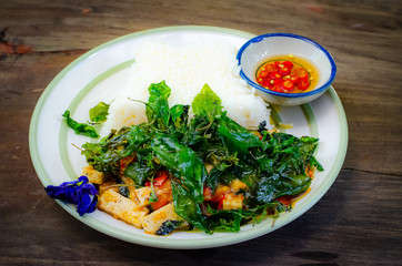fried rice with basil on old wood background.