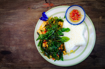 fried rice with basil on old wood background.