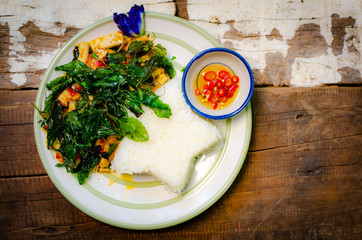 fried rice with basil on old wood background.