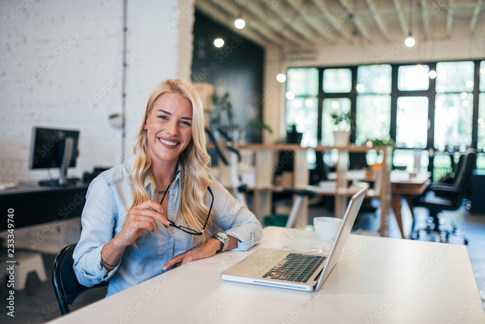 Wall mural Business portrait of a beautiful blonde woman in creative studio.