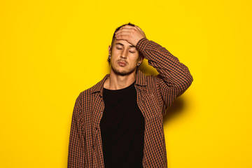 Young man with hand on forehead and expression of stress and worry