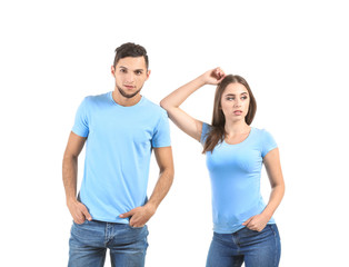 Young man and woman in stylish t-shirts on white background