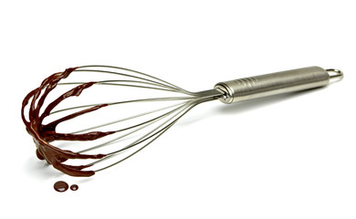 Chocolate immersed whisk isolated on white background