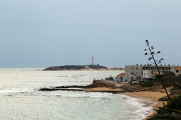 Sandy beach at Trafalgar in spain overlooking the sea the waves and the lighthouse