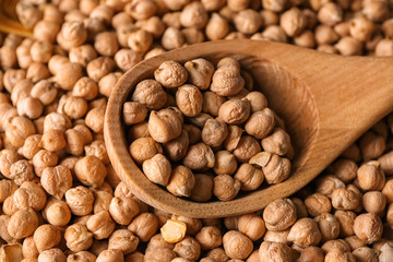 Dry chickpeas in wooden spoon, closeup
