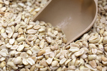 Pile of salted roasted peanuts and scoop on the market