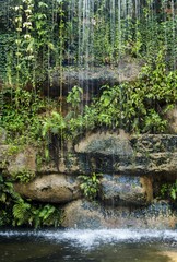Fototapeta na wymiar background image is a small waterfall, waterfall and garden ornaments