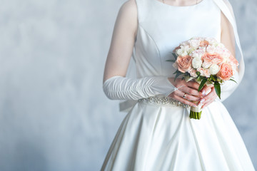 Sweet Wedding Bouquet with roses in the Hands of the Bride