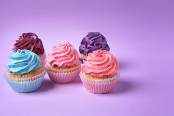 Tasty cupcakes on color background