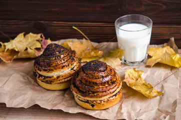 fresh bun with poppy seeds and a glass of milk