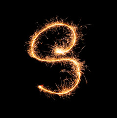 Sparklers forming letter S on dark background