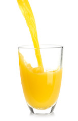Pouring of orange juice into glass on white background