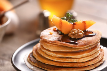 Hot tasty pancakes with pumpkin piece and chocolate sauce on plate, closeup