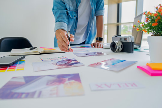 Asian advertising designer creative start-up team discussing ideas in office.