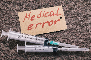 Syringes on the table and the inscription medical error