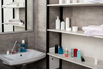Fototapeta na wymiar selective focus of modern bathroom with sinks and shelves with beauty products