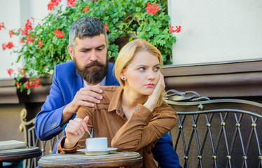 Woman and man with serious faces have coffee at cafe. Relations problems concept. Girl and bearded...