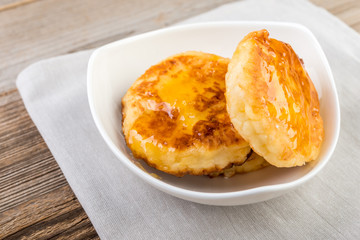 Cottage cheese pancakes, cheesecakes  with honey  on wooden background, healthy traditional  breakfast