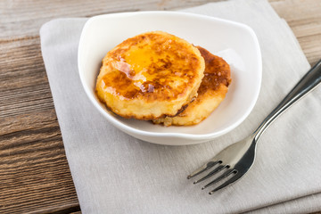 Cottage cheese pancakes, cheesecakes  with honey  on wooden background, healthy traditional  breakfast