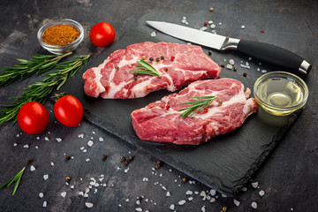 Fototapeta na wymiar Raw beef steak on black stone background. Selective focus