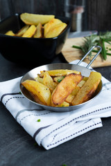 Fried Potatoes with herb Rosemary. Quick and Easy Dinners concept. Crispy Garlic Baked Potato Wedges