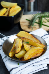 Fried Potatoes with herb Rosemary. Quick and Easy Dinners concept. Crispy Garlic Baked Potato Wedges