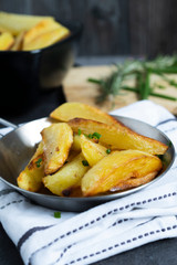 Fried Potatoes with herb Rosemary. Quick and Easy Dinners concept. Crispy Garlic Baked Potato Wedges