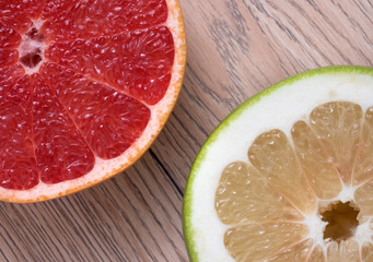 Green Sweetie or Pomelit and Red Grapefruit on wooden background.