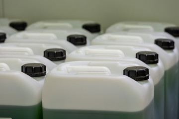 Several chemitry canisters in rows with green liquid