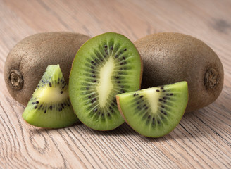 Ripe juicy kiwi fruit on wooden background.