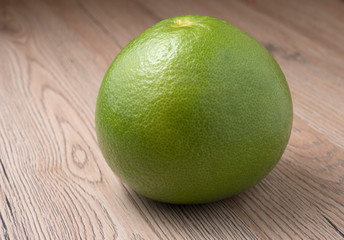 Whole Green Sweetie on wooden background.
