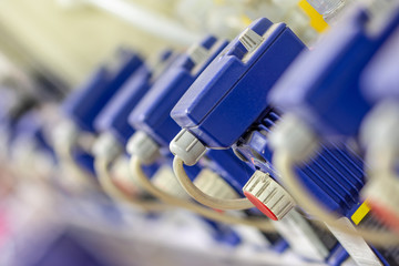 a row of several small  blue chemistry pumps