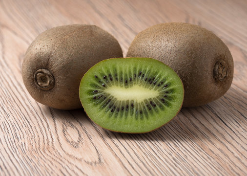 Ripe juicy kiwi fruit on wooden background.
